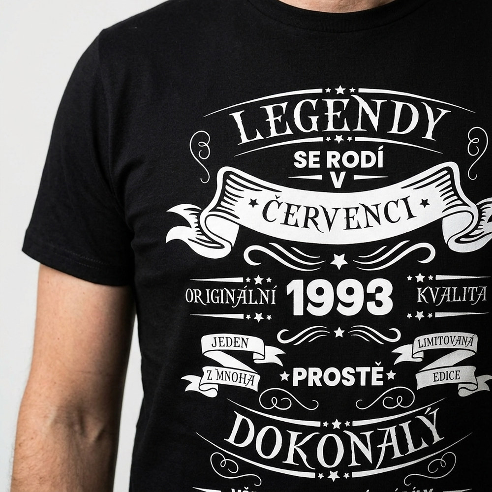 Detail nápisu Legendy se rodí na černém tričku